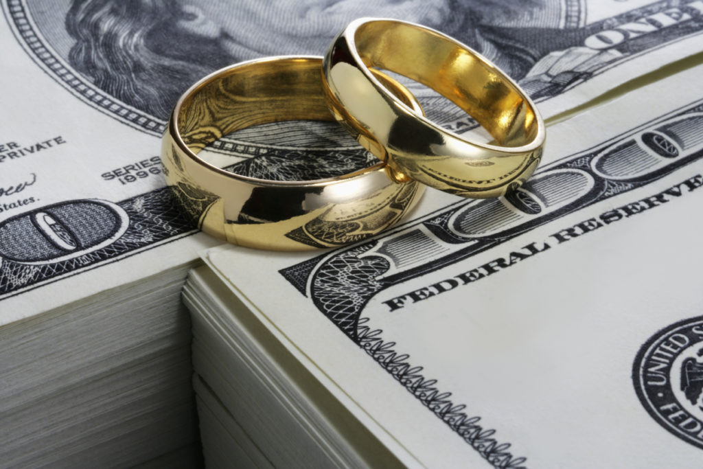 Wedding rings and stack of money